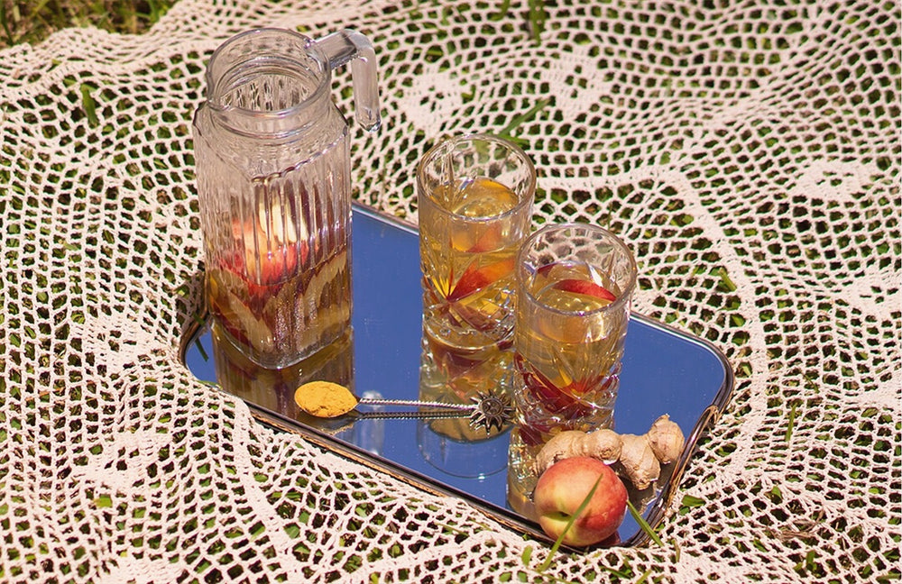 Ginger and peach white iced tea with Lion's Mane medicinal mushroom on a picnic rug